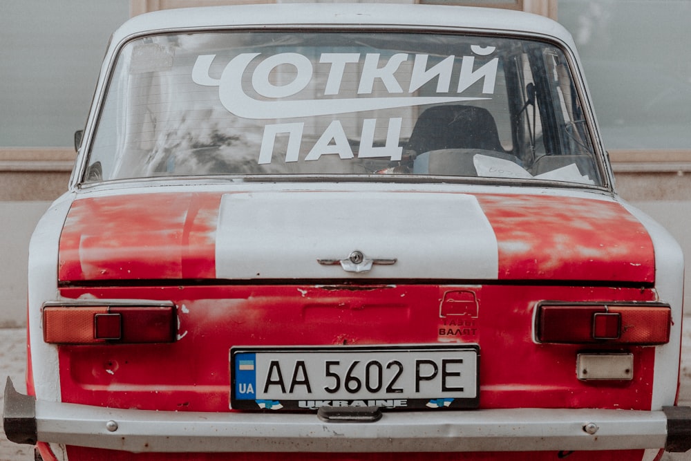 red and white vehicle parked in front of building