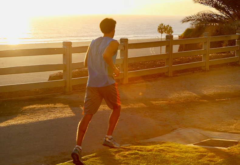 Dynamic runner sprinting along a coastal trail in Tenerife with ocean views.