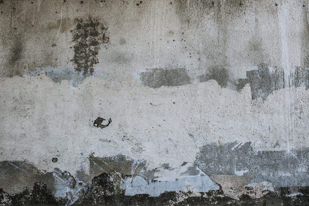 a black and white photo of a wall with peeling paint