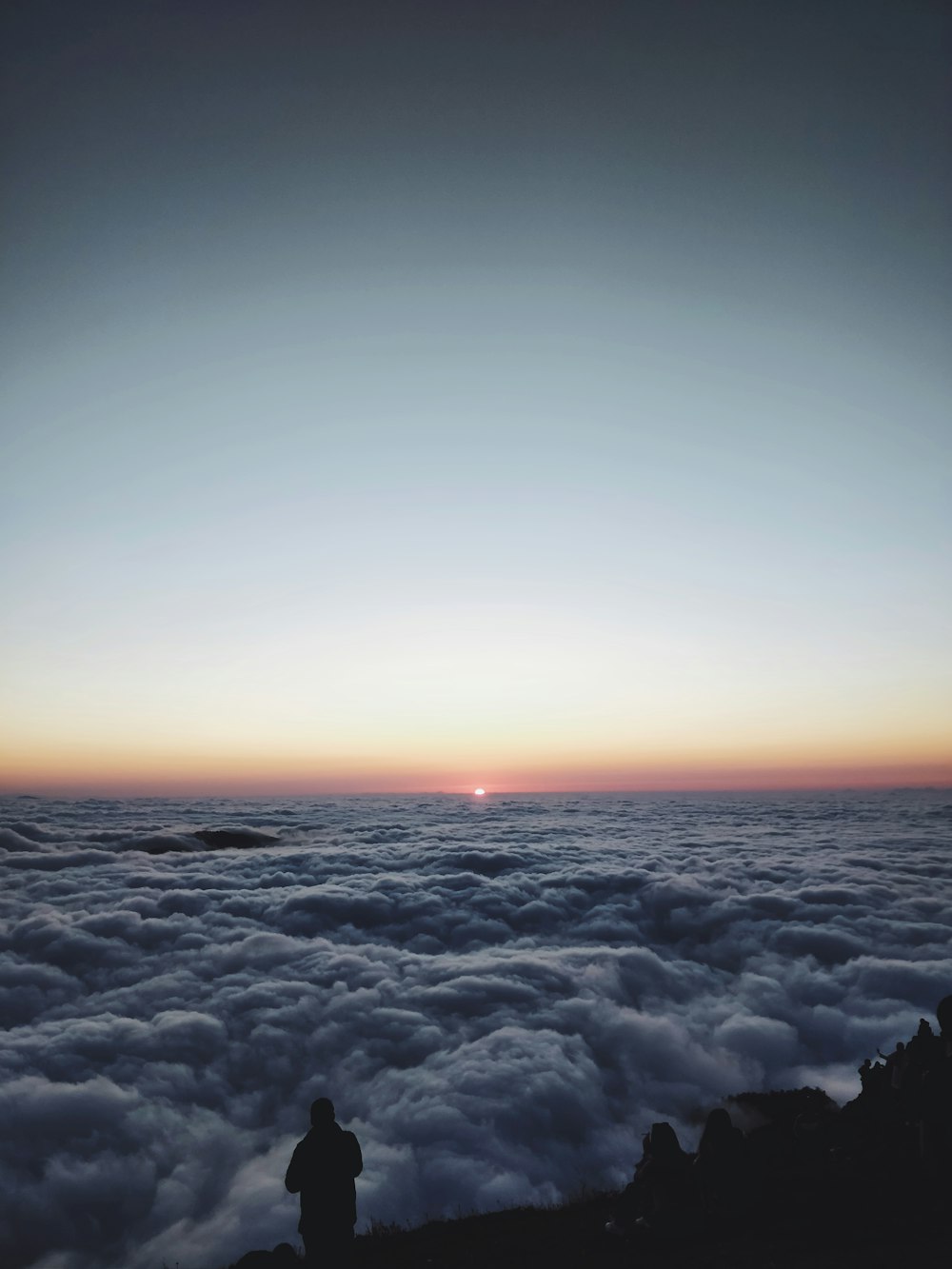 silhouette of person standing on cliff