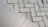 The image displays two different types of surfaces divided diagonally. The left side shows a smooth, possibly ceramic or concrete tile surface. The right side features a pattern of interlocking grey concrete bricks with a herringbone layout.