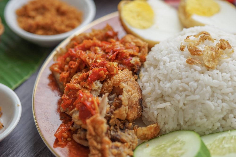 rice and fried meat with egg in plate