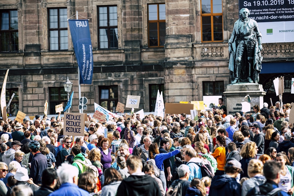 Mannsstatue umgeben von Menschen