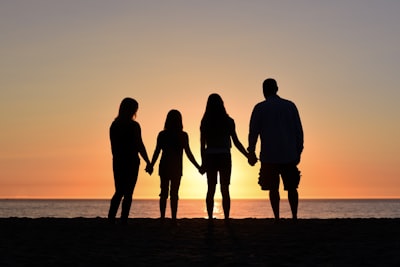 four people on seashore family teams background