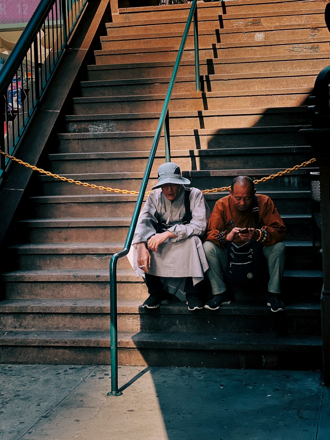two men sitting on concrete stairs