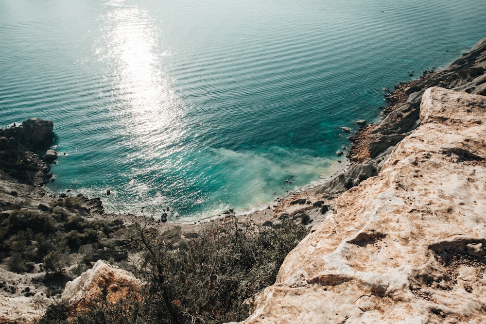 a body of water sitting next to a rocky cliff