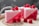 Handmade soap bars with a pink and red color scheme are garnished with fresh raspberries. The soap has a translucent lower half and a solid, frothy white top with the word 'HANDMADE SOAP' embossed on the side.