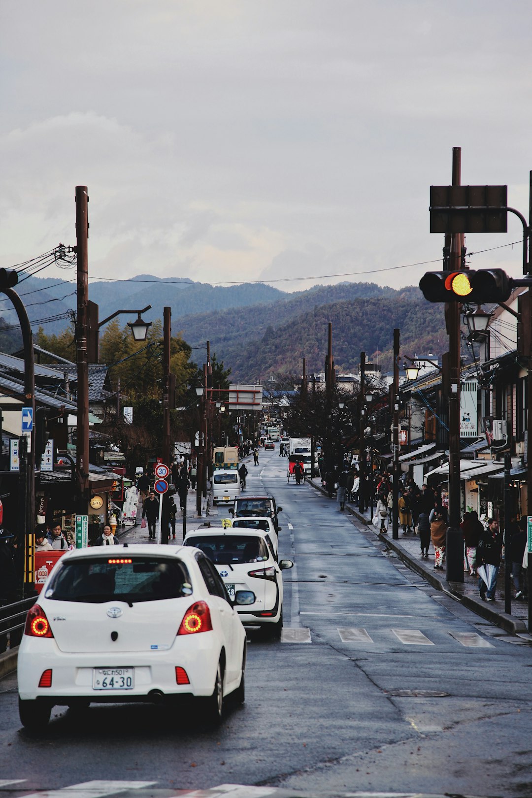 cars on road and people at the sidewalk during day