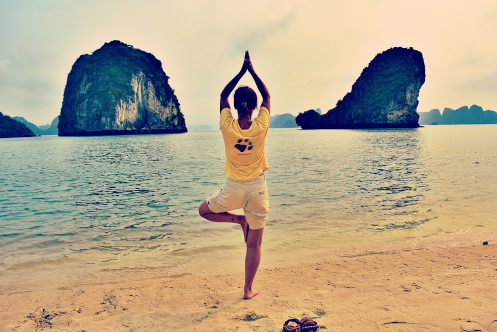 man wears yellow crew-neck t-shirt on the seashore