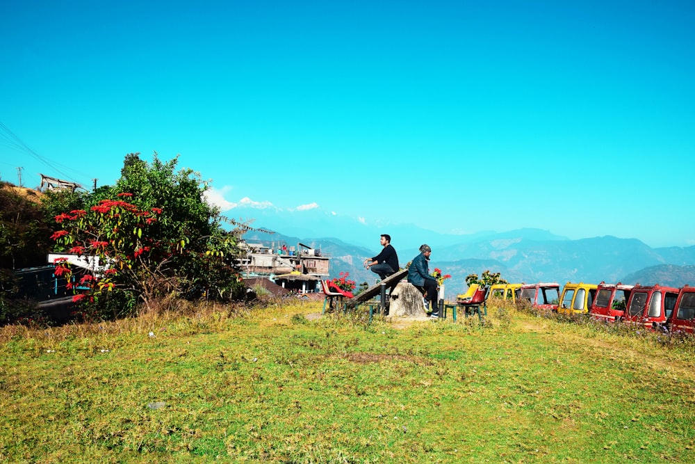 dois homens sentados na pedra durante o dia