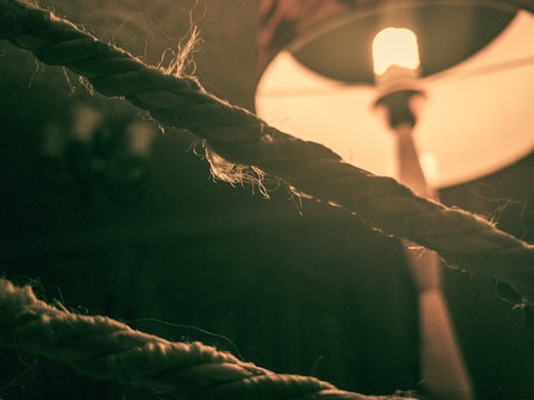 Close-up of a macramé light glowing warmly in a cozy room.