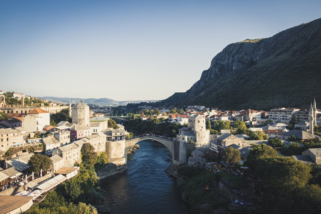 aerial photography of houses and buildings near bridge viewing mountain during daytime, View of Mostar | Bosnia