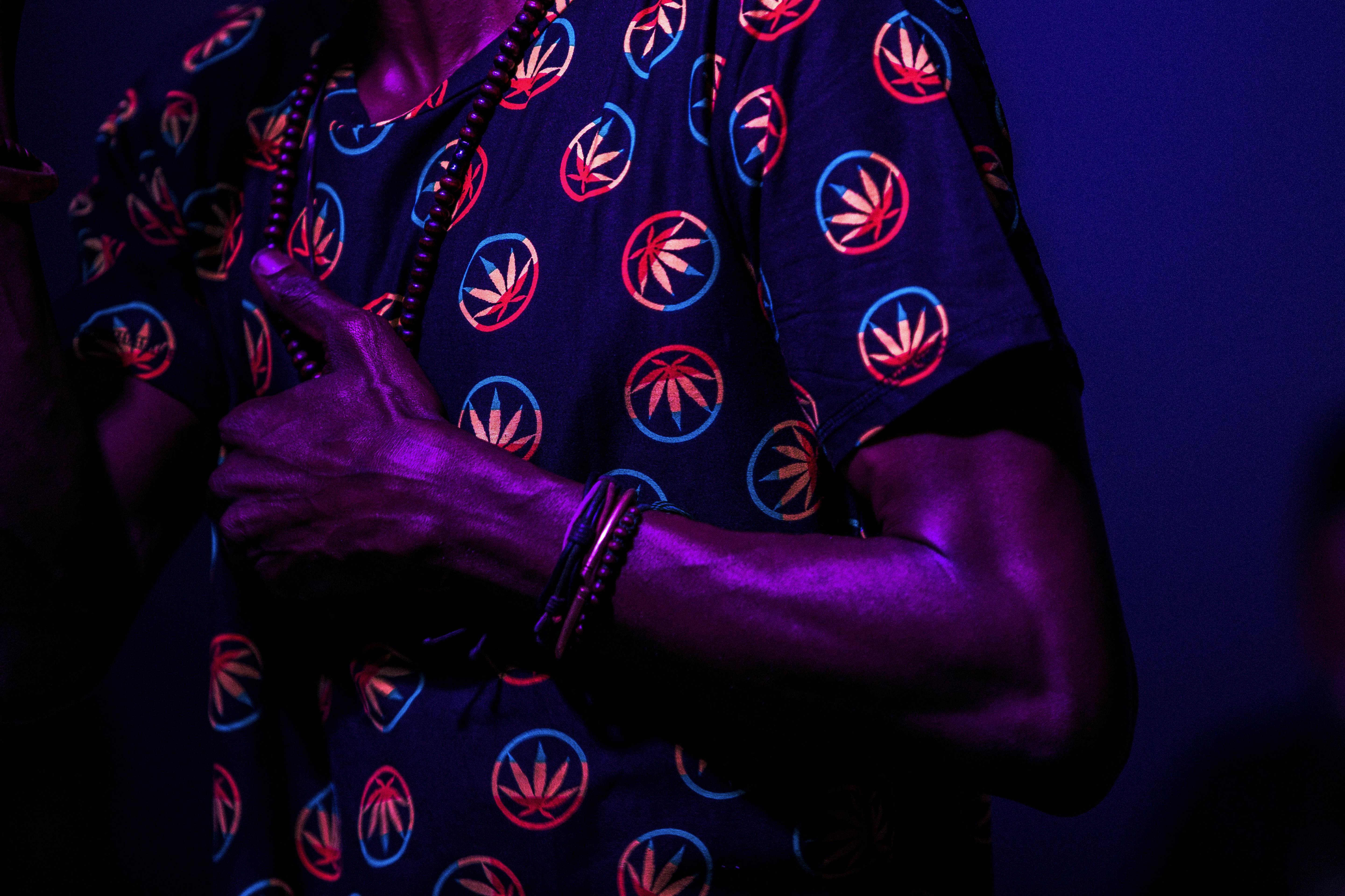 person wearing blue and red cannabis print shirt standing