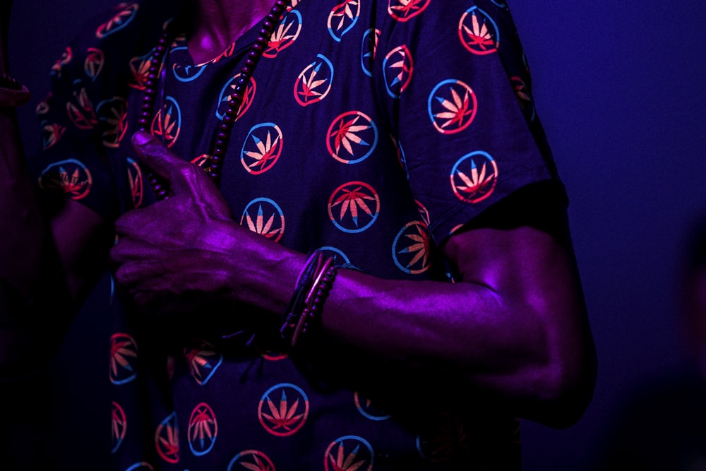 person wearing blue and red cannabis print shirt standing