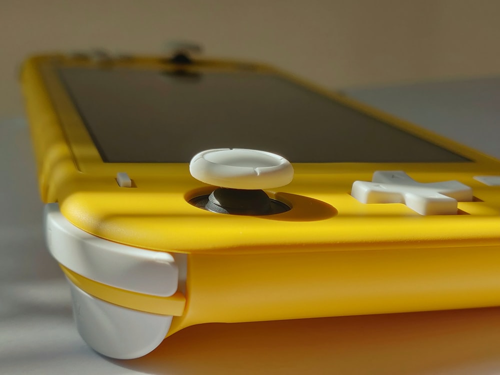 Consola de juegos con mango amarillo y blanco