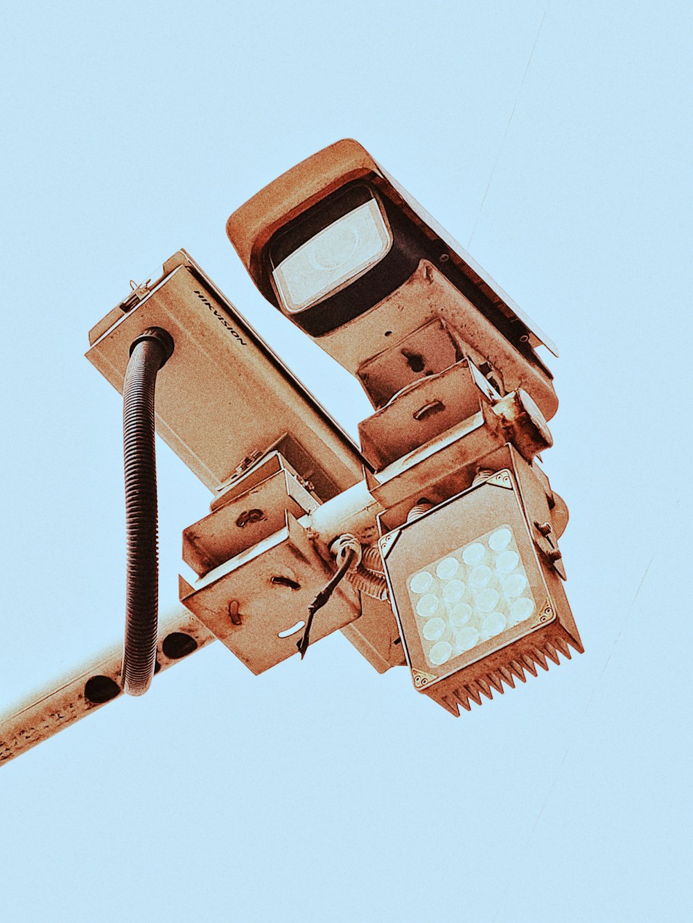 brown CCTV camera under blue sky during daytime