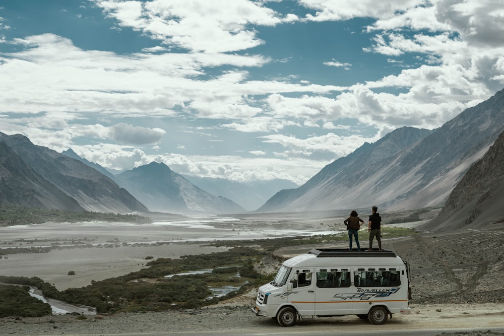 two person on top of white van