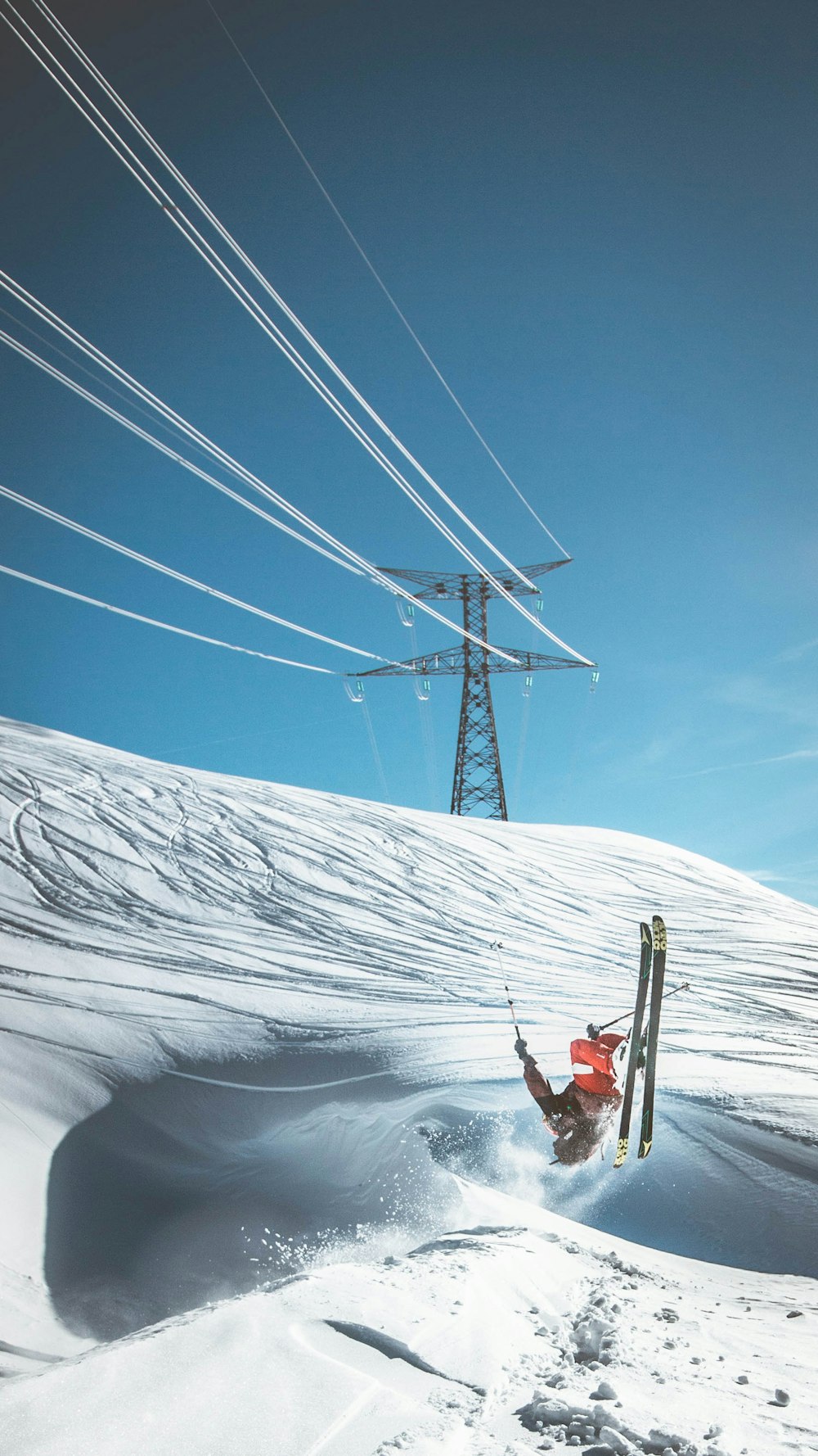 Homem esquiando na neve perto da torre elétrica