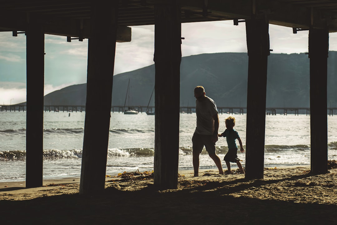 man walking with boy on shore