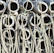 A stack of cylindrical concrete pipes with ropes intertwined around them. The pipes appear weathered and are arranged in a dense, repetitive pattern.
