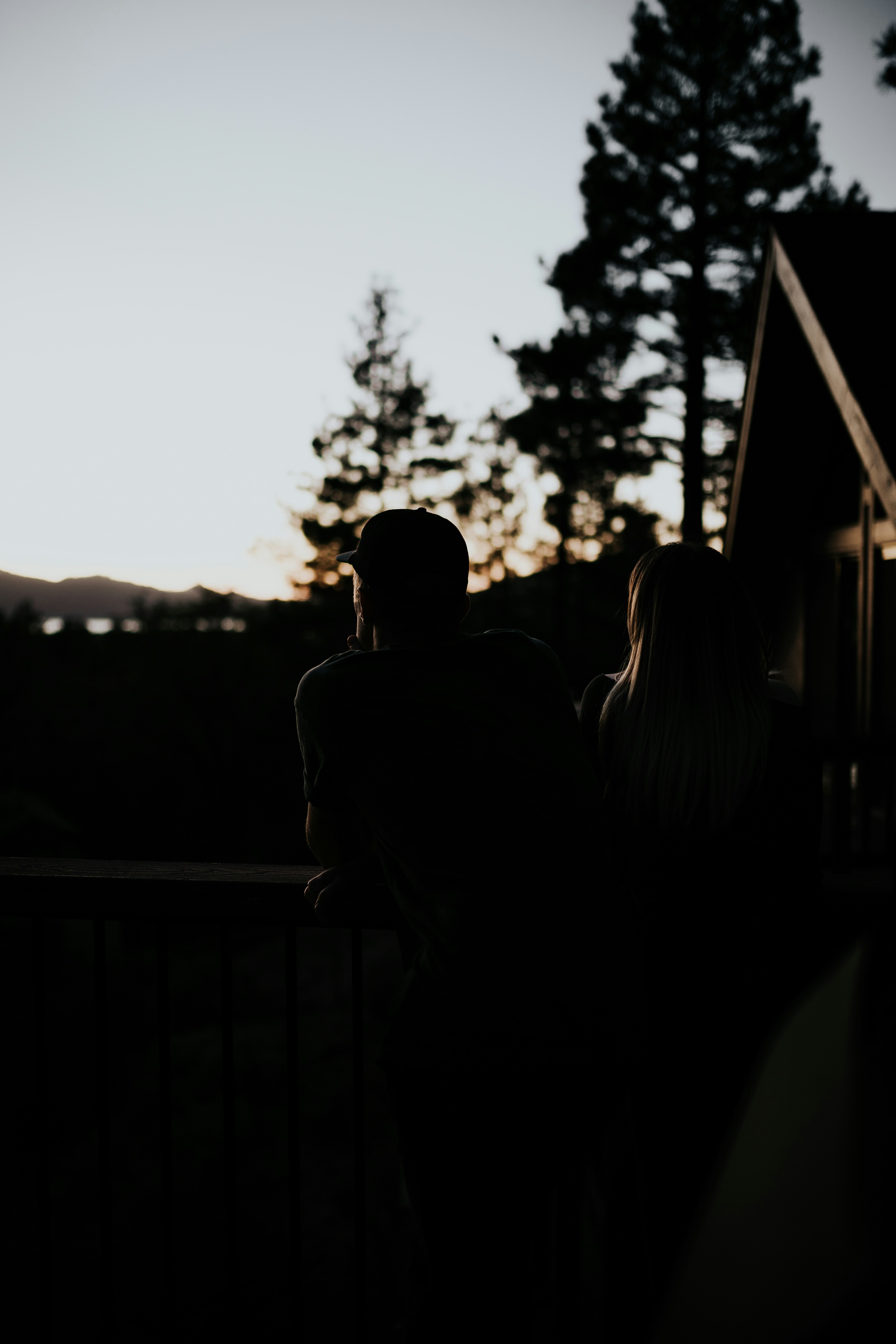man and woman sitting beside handrail