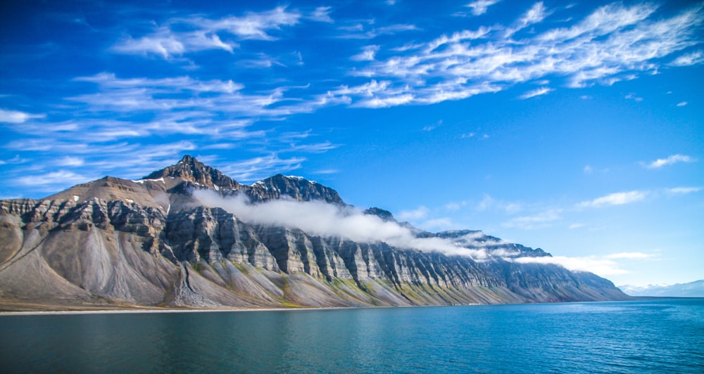 a large mountain with a body of water in front of it