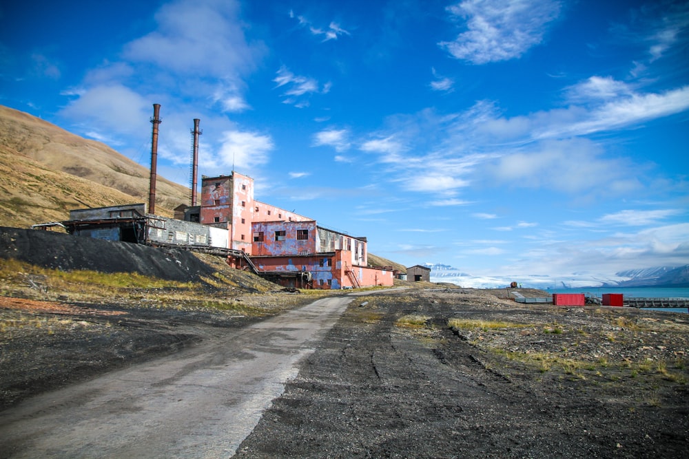 road near orange factory and body of water