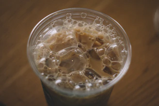 Close-up of a cold brew coffee with ice cubes, highlighting the deep rich color and creamy foam.