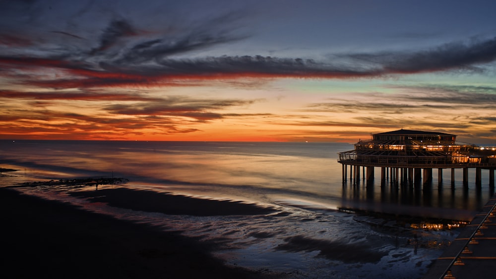 a pier at sunset with the sun going down