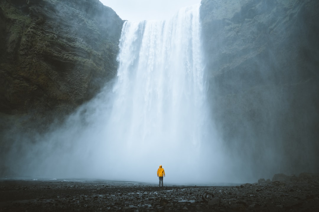 person standing near waterfalls