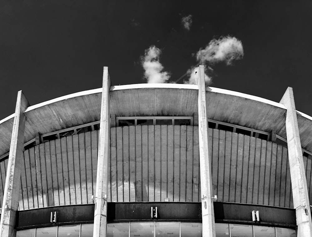 foto in scala di grigi dello stadio sotto il cielo sereno
