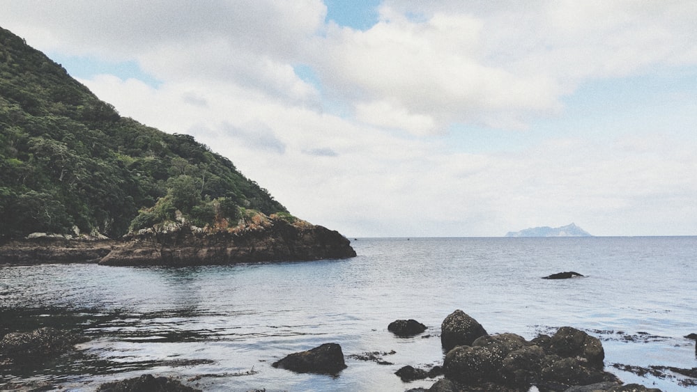 rocks on shore near hill