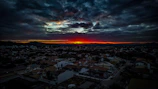 A panoramic view of a sprawling city skyline under a dramatic sunset.