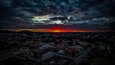 A panoramic view of a sprawling city skyline under a dramatic sunset.