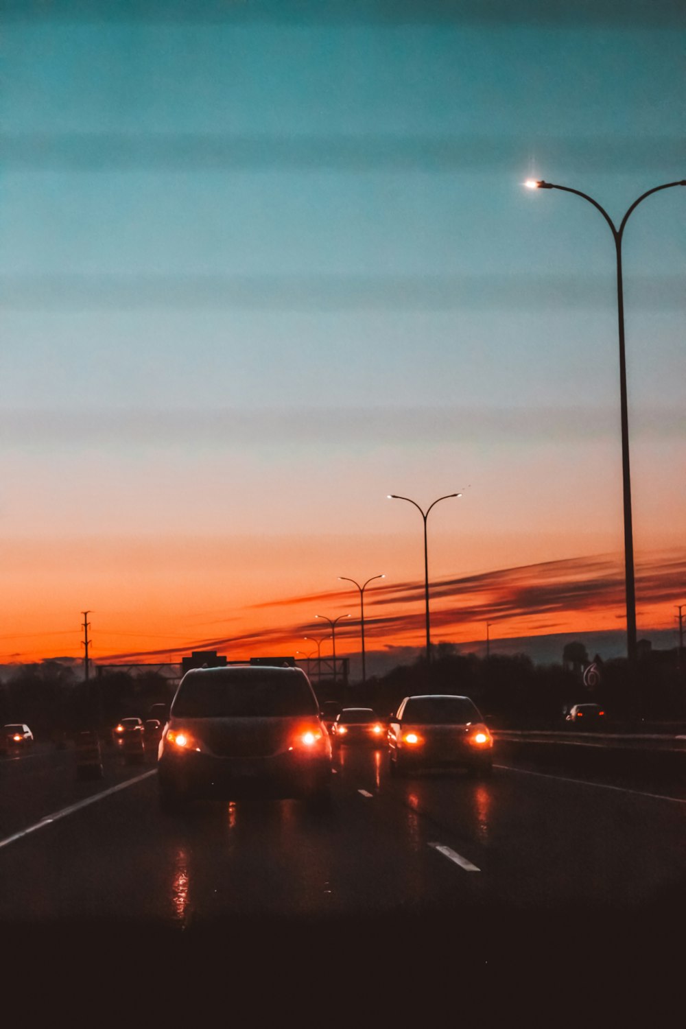 vehicles crossing on road during sunset