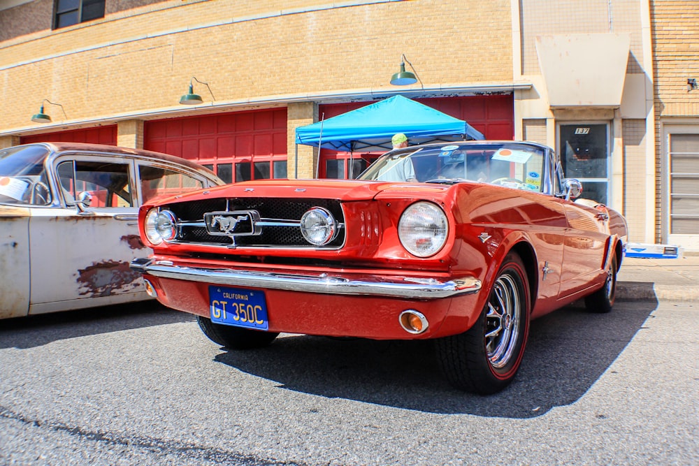 red Ford Mustang coupe parked in front of store