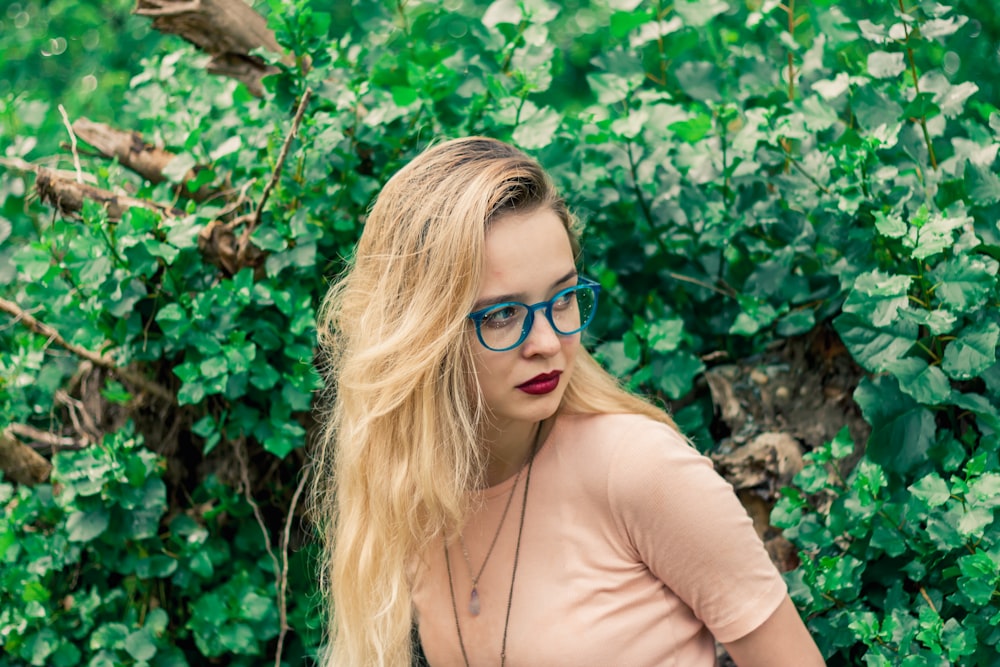 woman wearing eyeglasses standing near plant