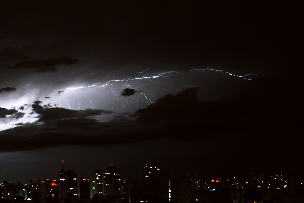 a lightning bolt hitting over a city at night