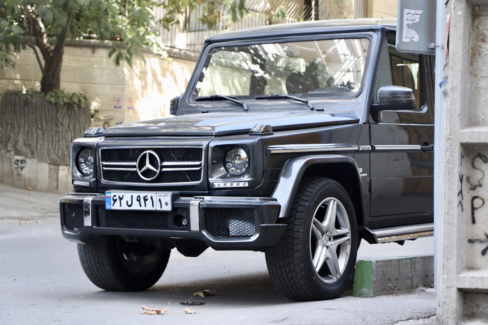 black Mercedes-Benz vehicle parked beside wall