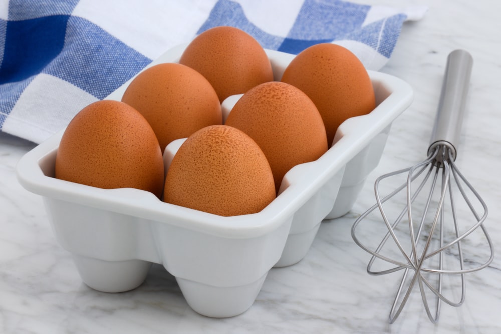 six œufs bruns dans un plateau