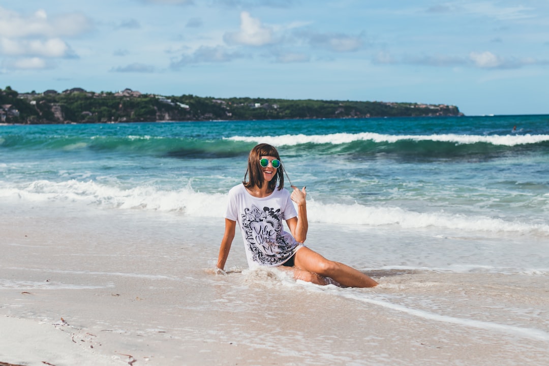 woman sitting on shore during daytime