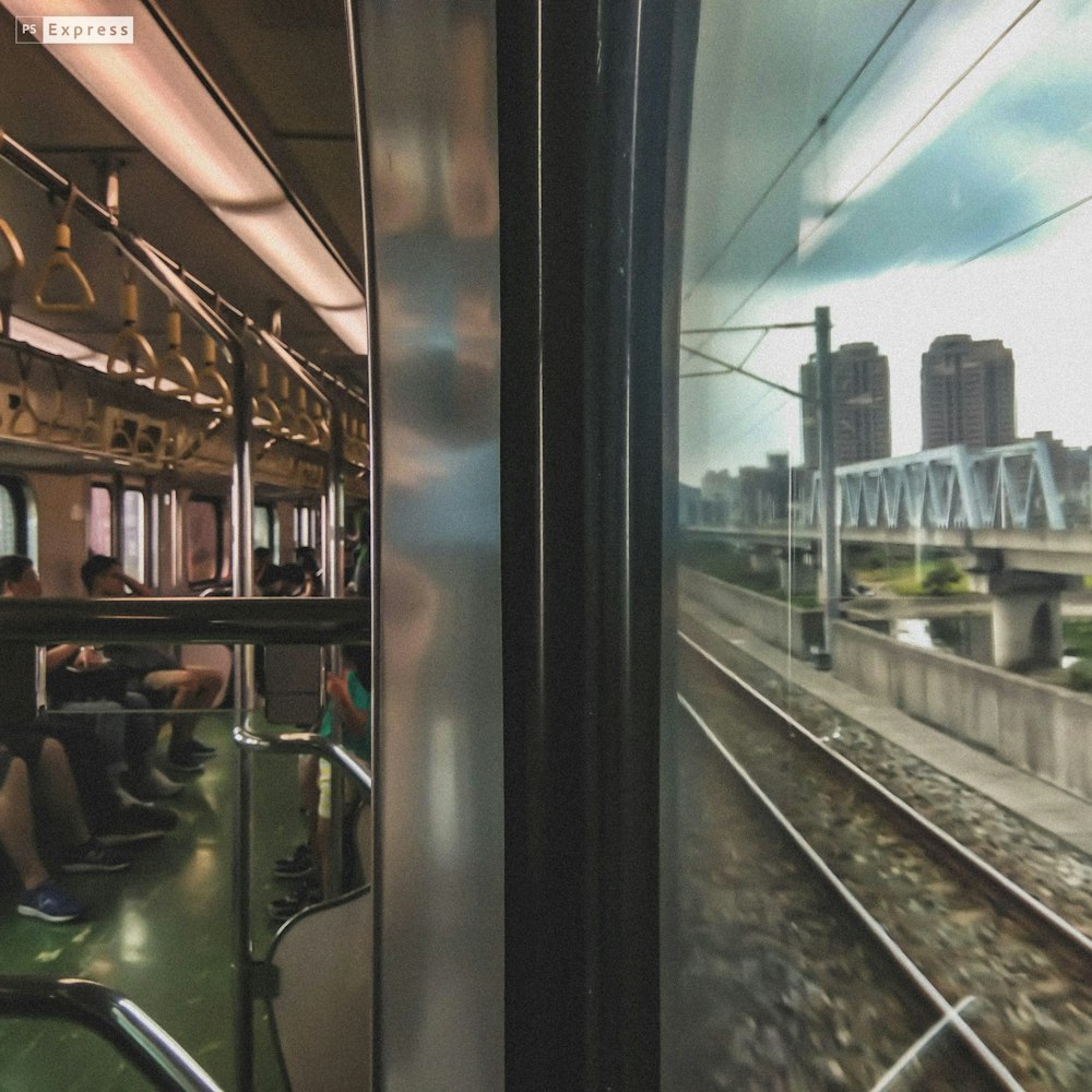 a group of people sitting on a train looking out the window