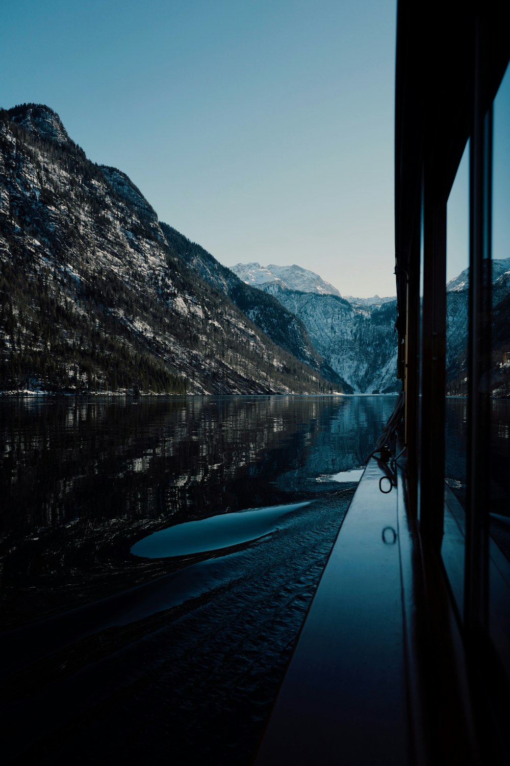 a boat traveling down a river next to a mountain range