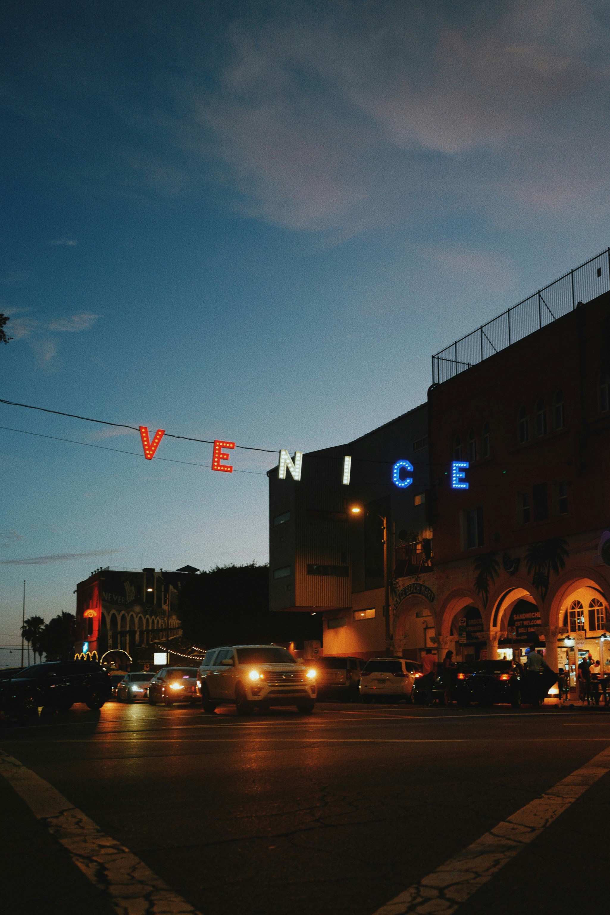 Eine nächtliche Stadtstraße mit Autos, die am Straßenrand geparkt sind