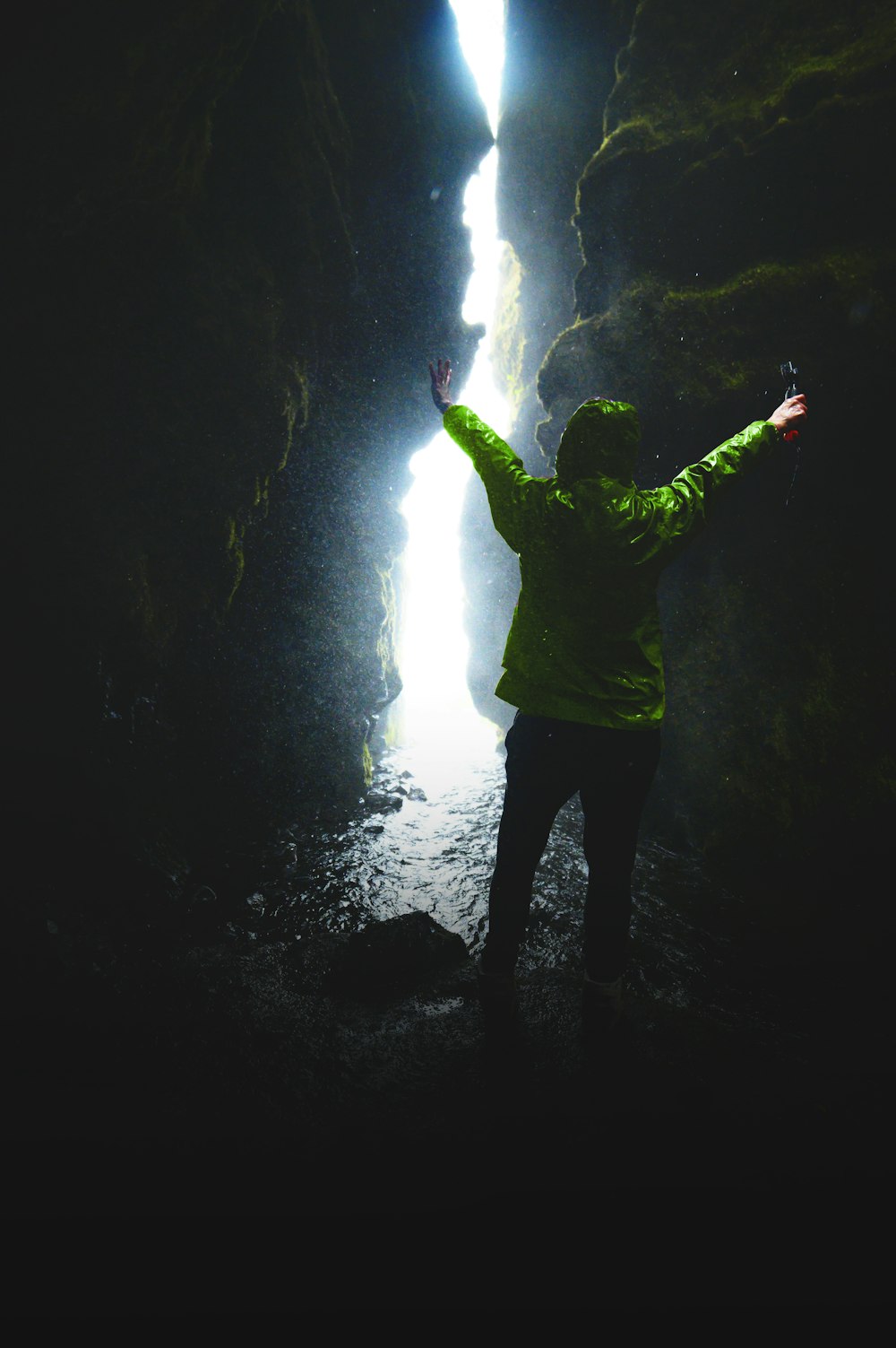 person wearing green jacket and black pants on tunnel