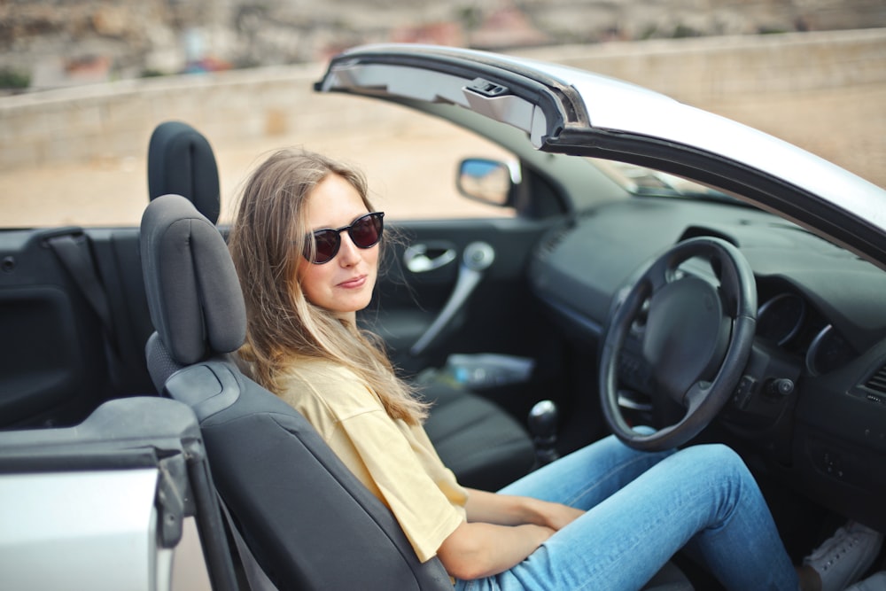 Donna sorridente che si siede sul veicolo in bianco e nero