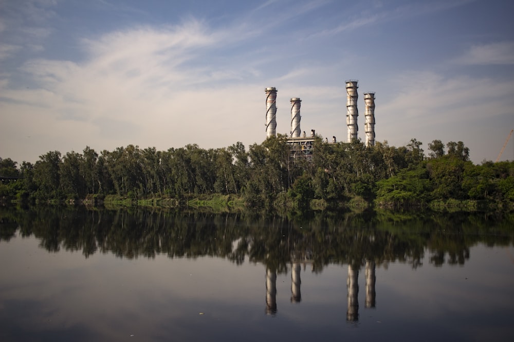 reflection of building with towers and surrounded by trees on body of water during daytime