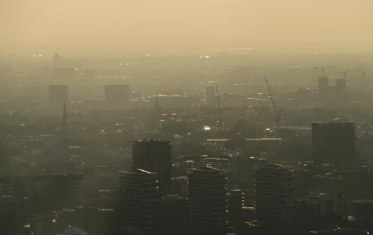 Delhi skyline with visible smog and pollution haze, conceptual image linking urban air quality to sk