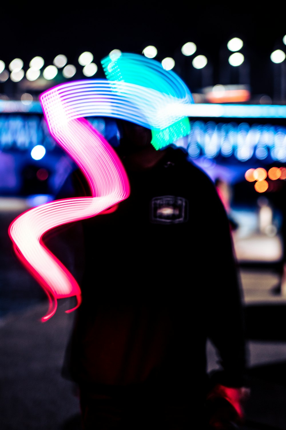 a man standing on a street holding a neon object