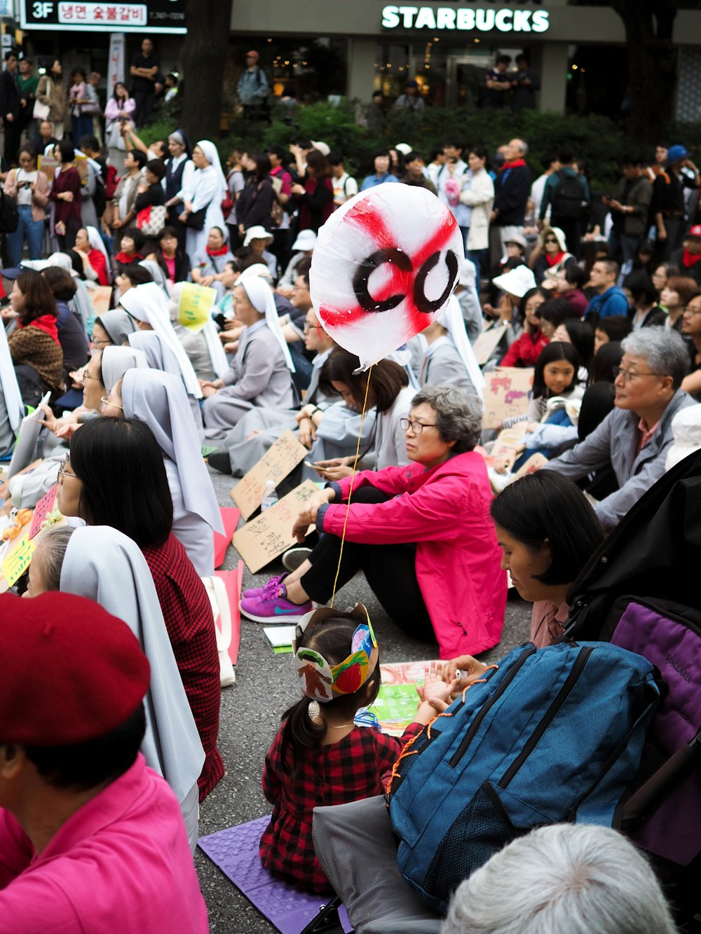 a large group of people sitting on the ground